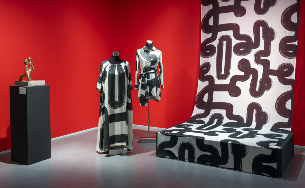 Papu Design Oy:n vaatteita sekä kankaita esillä taidemuseon näyttelysalissa.