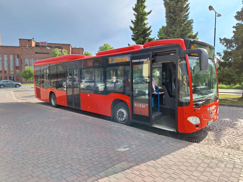 Kuva punaisesta R-liikenteen linja-autosta pysäkillä